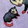 Closeup view of possum cross stitch pattern. This is a closeup of the baby sitting next to mama specifically. He is facing her. Even though he is much smaller than her, he is in the exact same pose (however mirrored). His tail is pink.