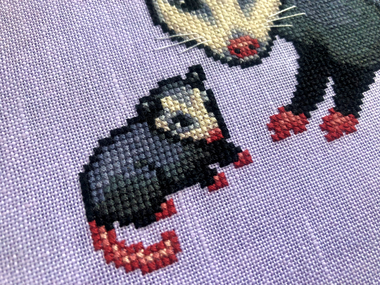 Closeup view of possum cross stitch pattern. This is a closeup of the baby sitting next to mama specifically. He is facing her. Even though he is much smaller than her, he is in the exact same pose (however mirrored). His tail is pink.